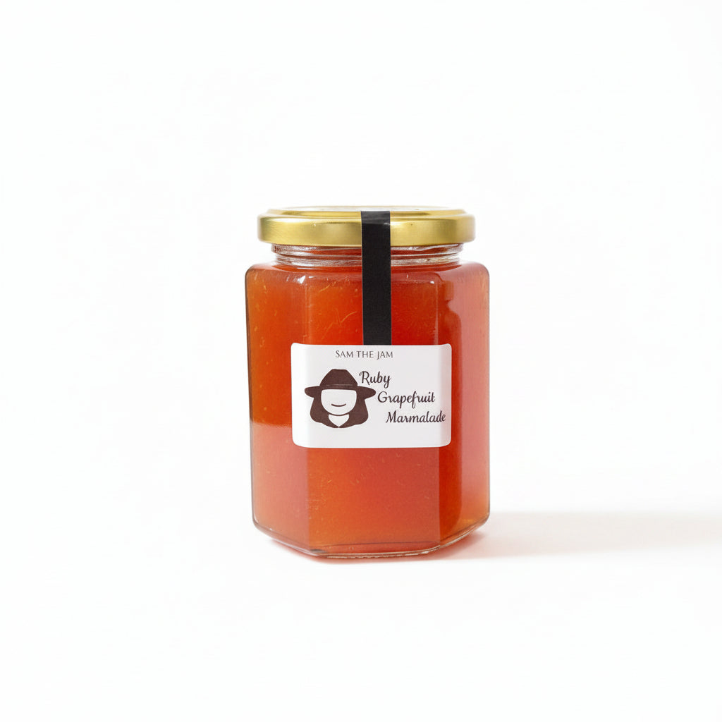 A glass jar of Sam the Jam Ruby Grapefruit Marzipanite jam with a gold lid and a white label featuring a cartoon character, set against a plain white background.